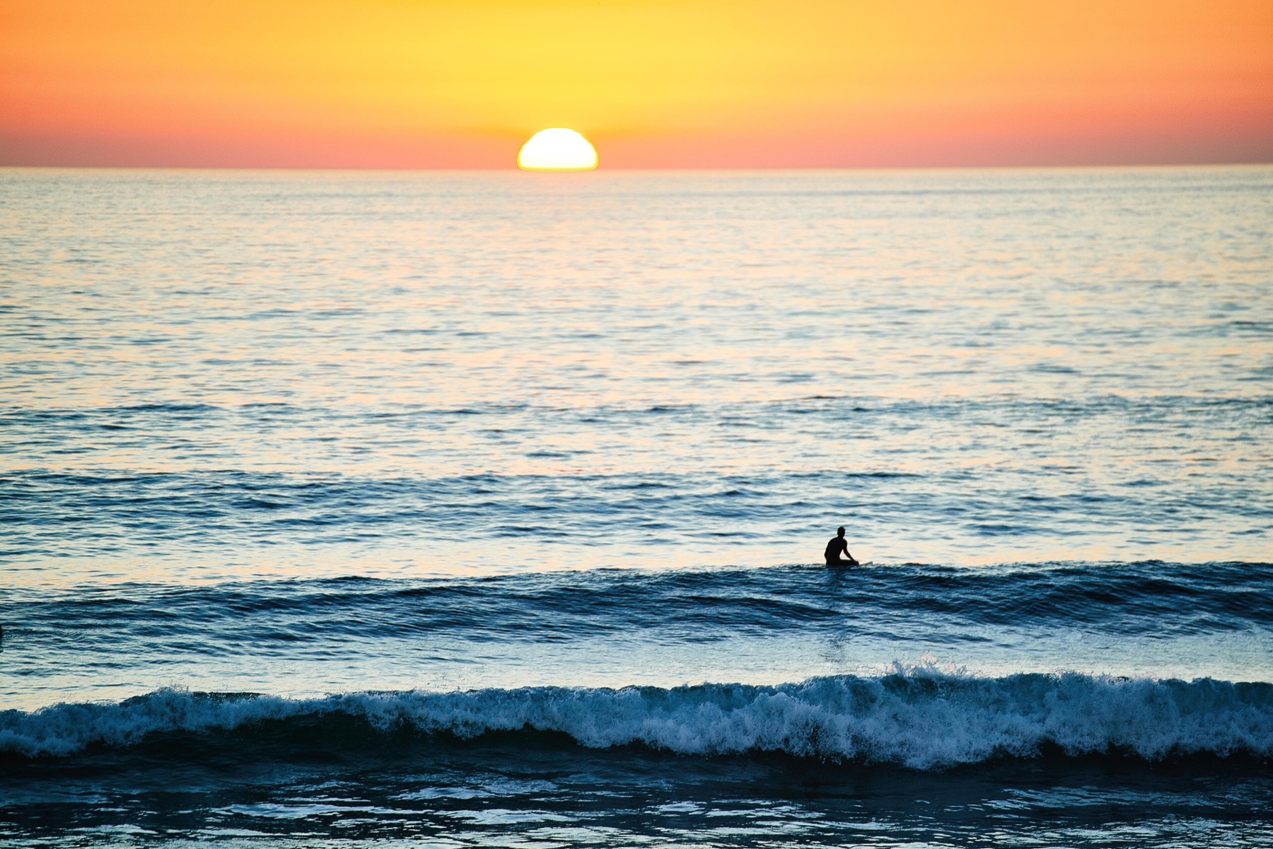 Surfeur au large d'Hossegor au coucher du soleil