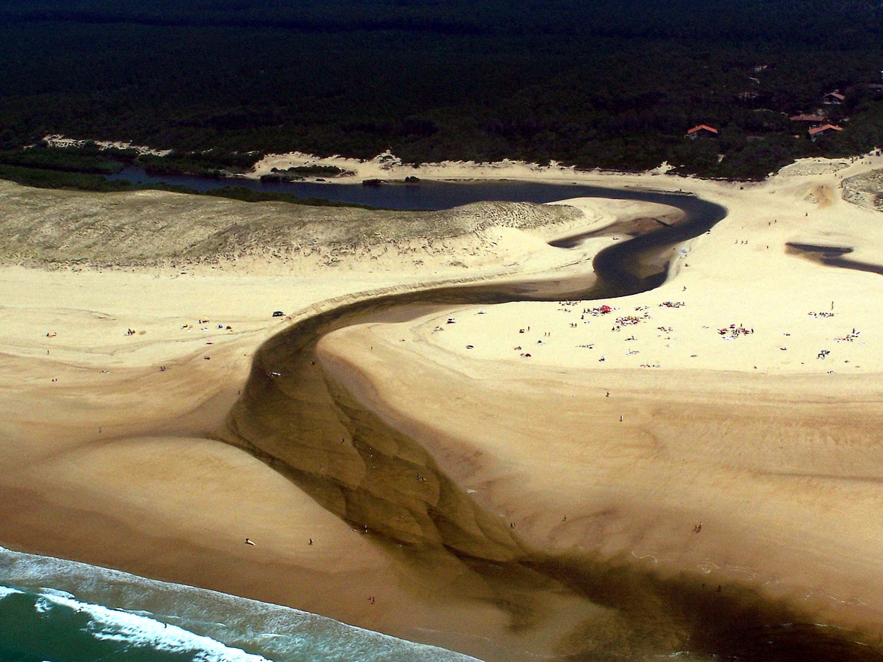 Le courant d'Huchet serpentant sur la plage jusqu'à l'océan, vu d'avion