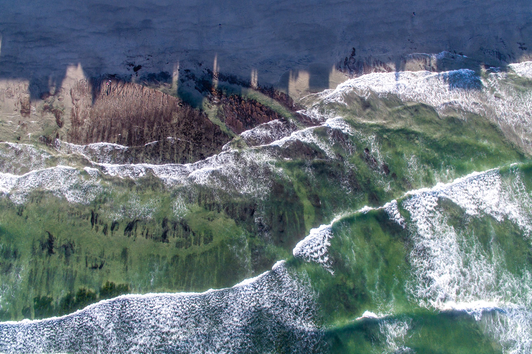 Vagues qui déroulent le long d'une côte au lever du jour