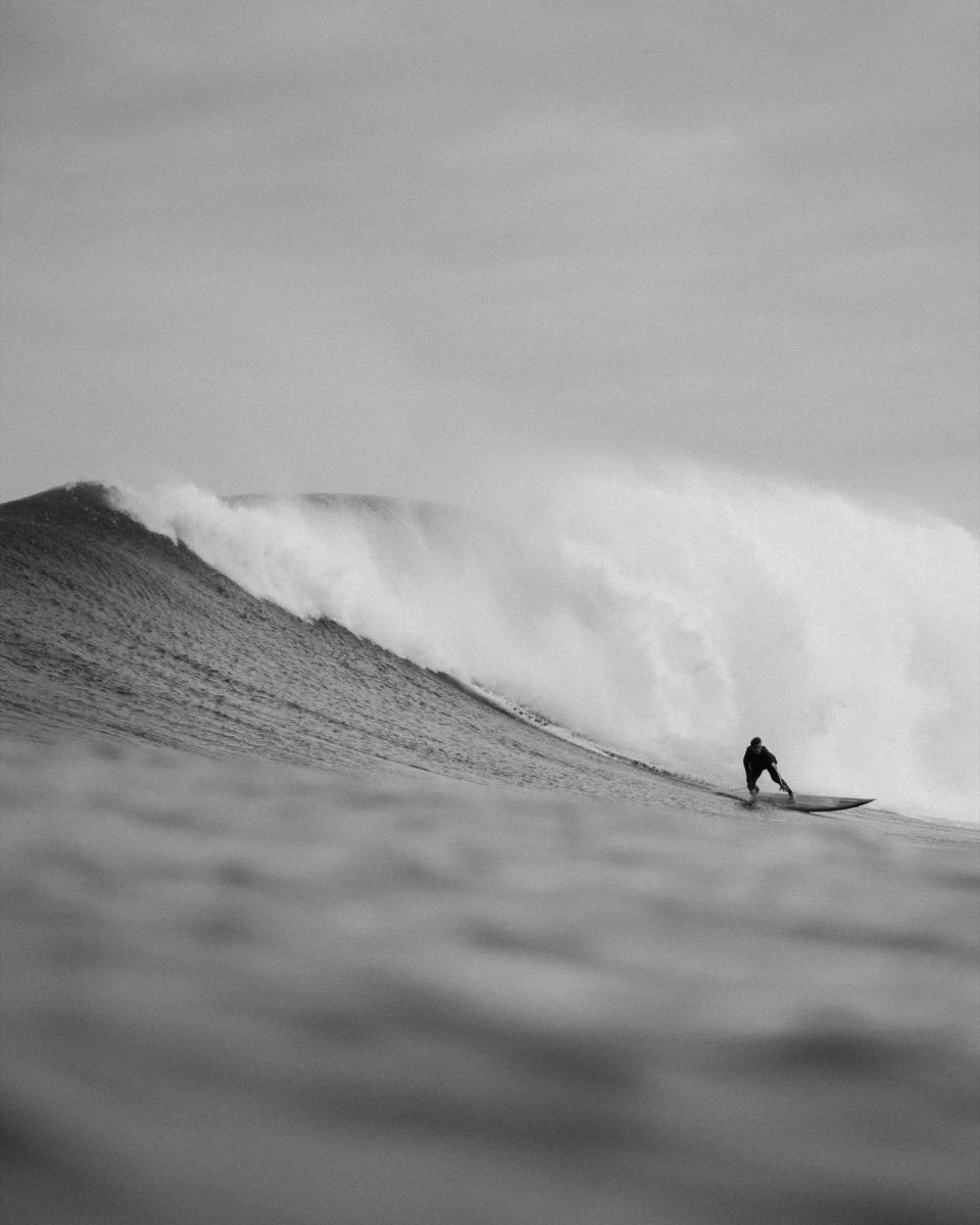 Surfeur seul sur une vague immense, noir et blanc