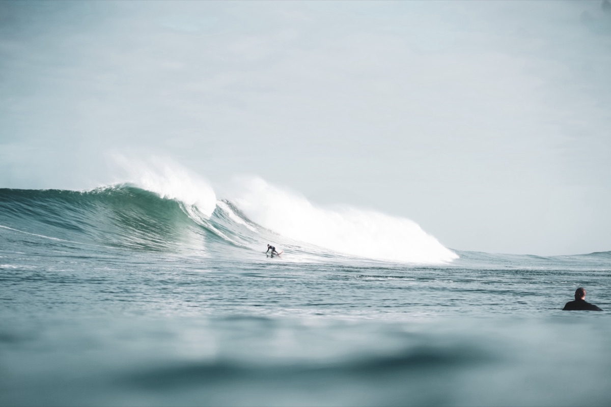 Surfeur en glisse sur une vague turquoise