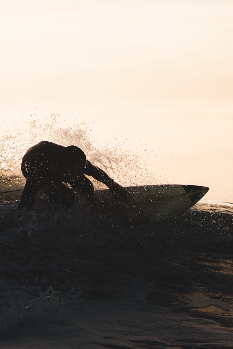 Surfeur à contre-jour doré, éclaboussures
