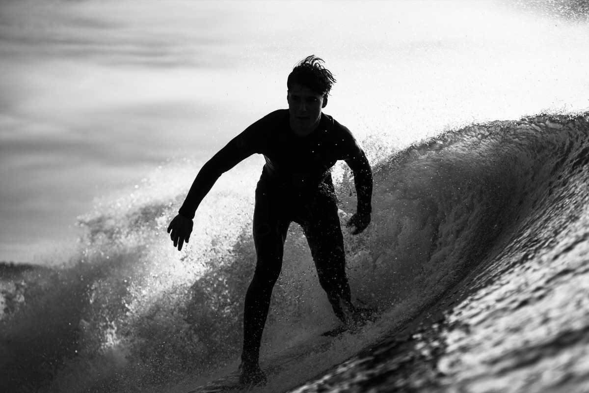 Surfeur dans le tube, contre-jour, noir et blanc